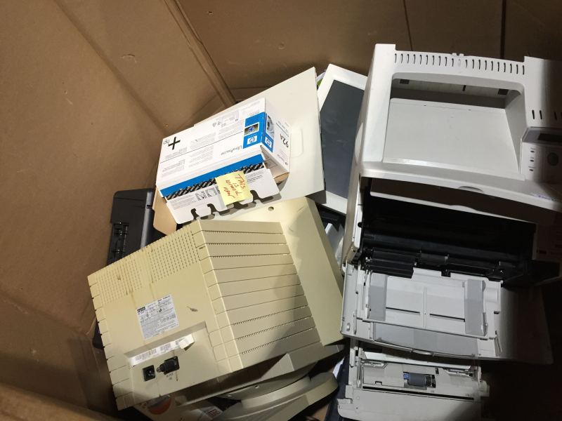 Cardboard bin with broken printers and monitors inside.